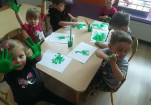 Dzieci pokazują pomalowane farbą dłonie